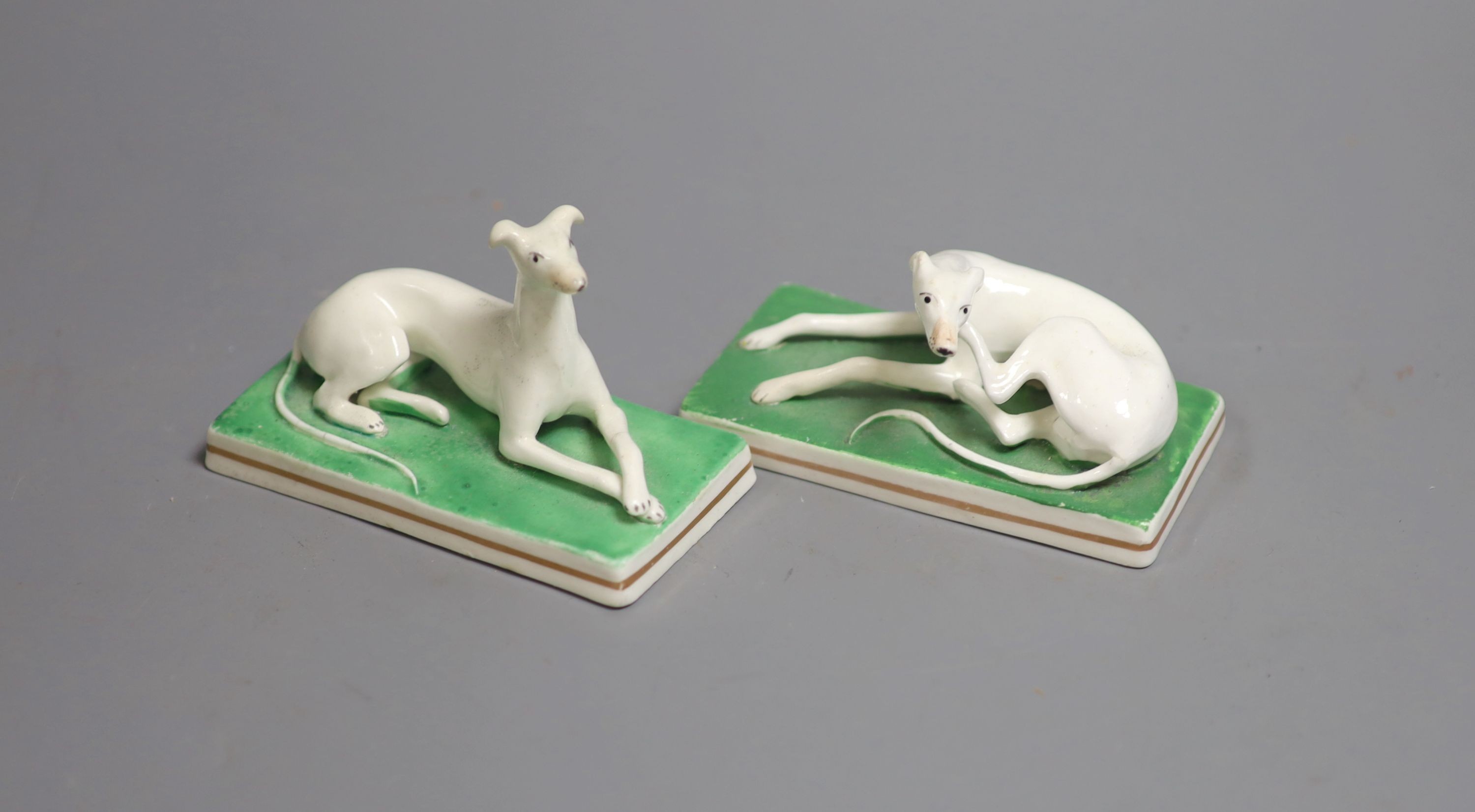 A pair of Staffordshire models of greyhounds, c.1830-50, each on rectangular bases, 10.2cm long